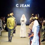 由文化部主辦之 26AW 臺北時裝週開幕秀新創舉，焦點模特兒手持《觀音菩薩普門品》，結合佛教文化音樂，以行動演繹走步，詮釋 「SA TA NA MA」 生命循環與佛學哲思意象。《觀音菩薩普門品》 為國立故宮博物院與僧伽林文化出版有限公司共同合作之國寶復刻經書。圖/楠西萬佛寺