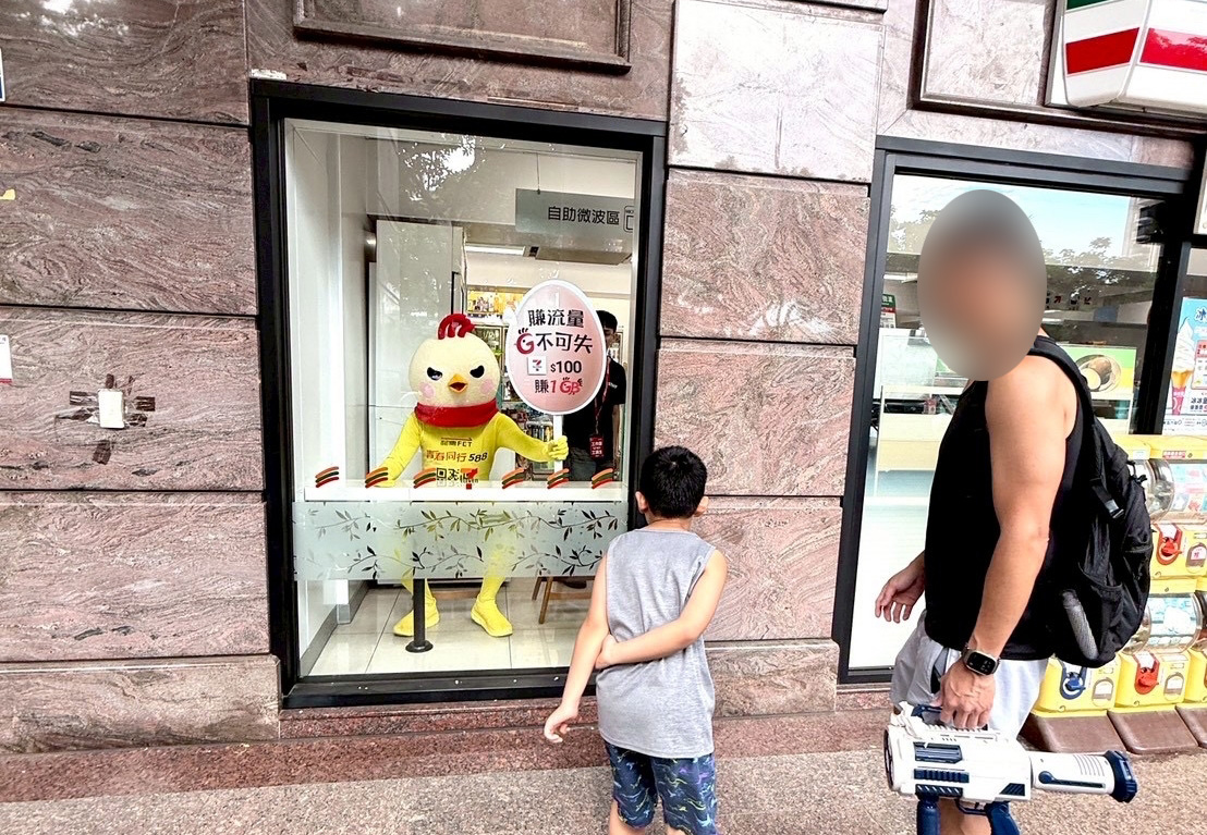 神秘巨型小黃雞出沒多間7-ELEVEN,路過民眾好奇圍觀。(圖/翻攝自網路)