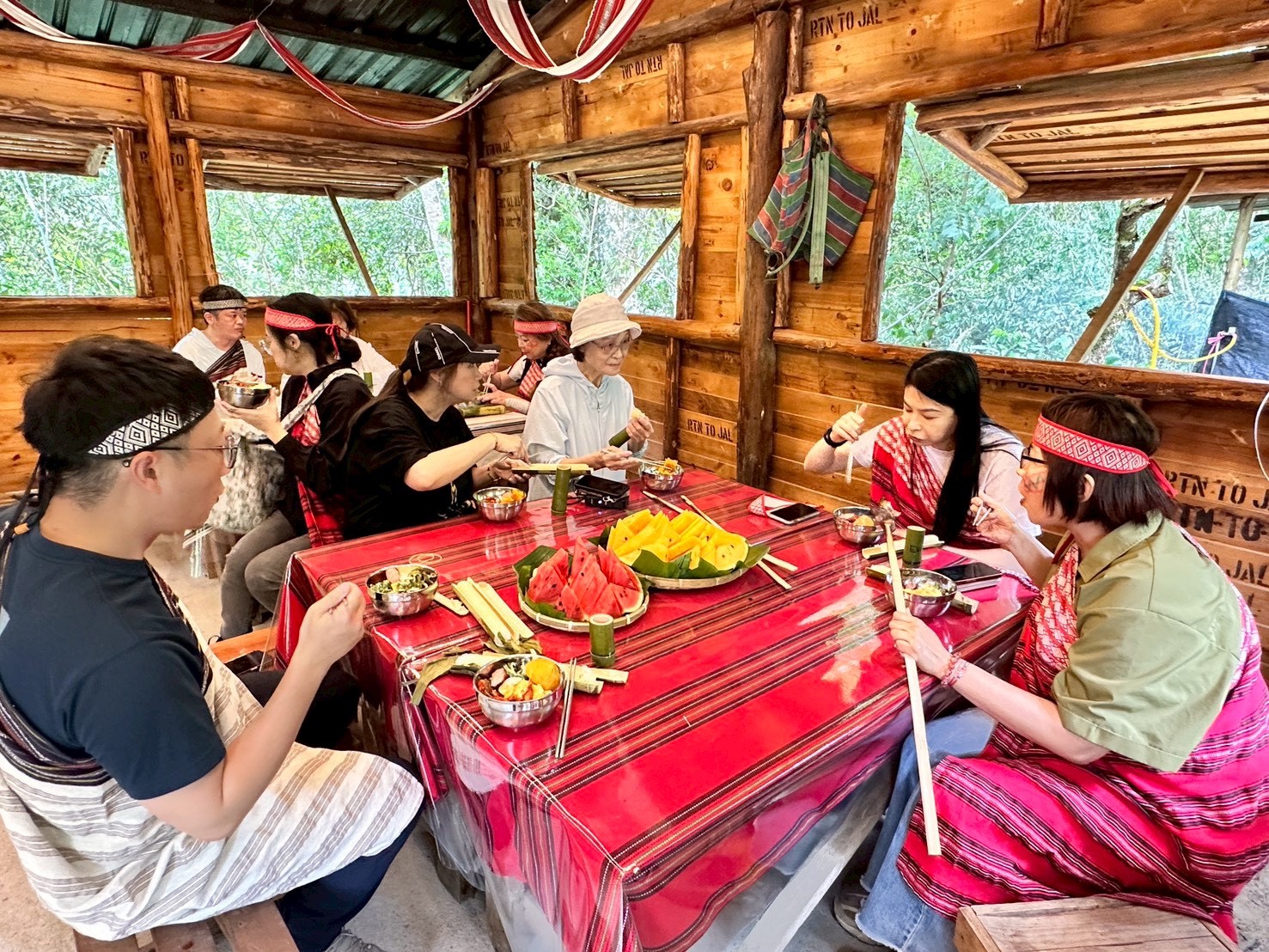 參加「漫遊烏來小旅行」的民眾穿上泰雅族傳統服飾,在原民風格木屋內享用部落特色料理,透過美食與文化交流,深入感受烏來泰雅族生活魅力。(圖/新北市烏來區公所提供)